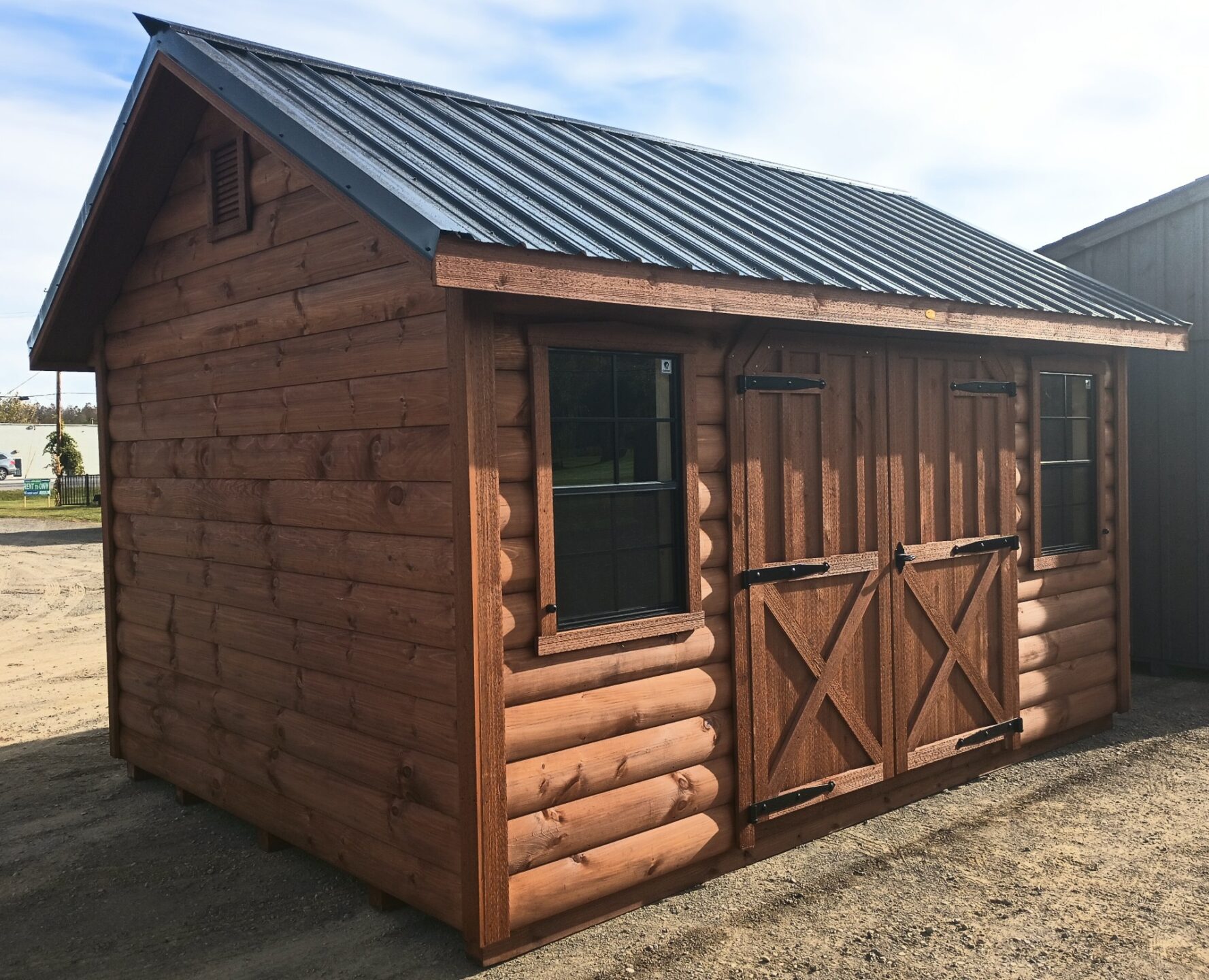 Log sided shed with double doors and windows on 14' long side and metal roof