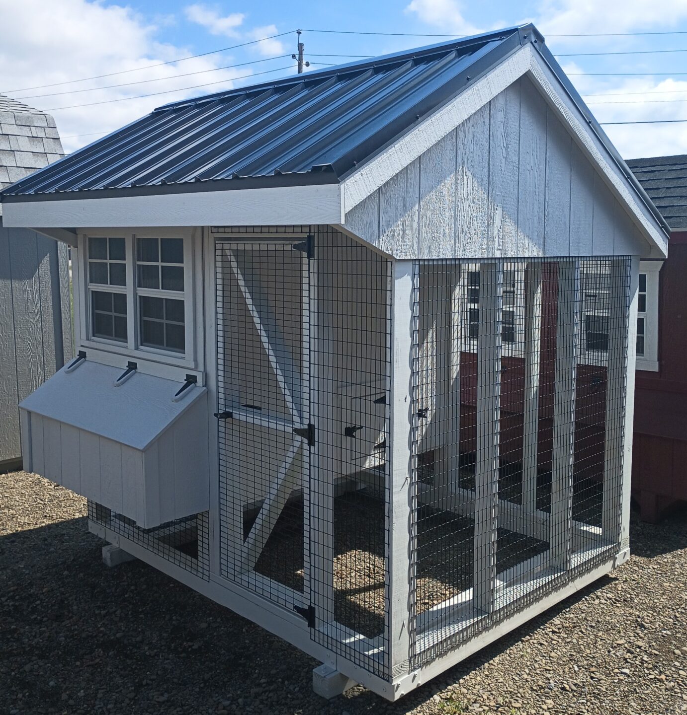 Small white chicken coop with two windows, nesting boxes and metal roof
