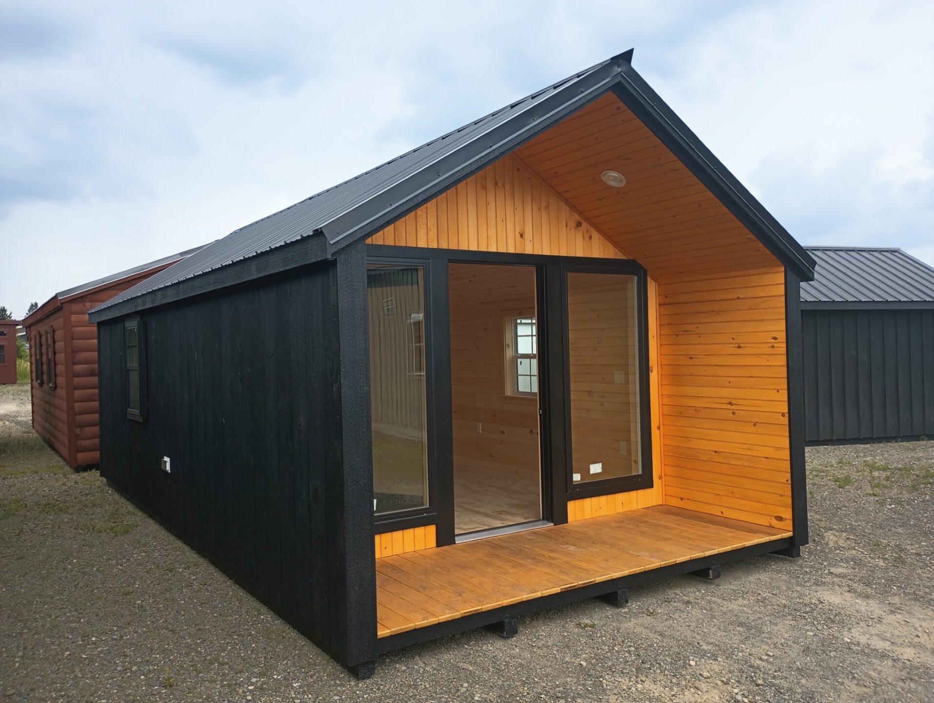 Black cabin with small front porch and glass doors