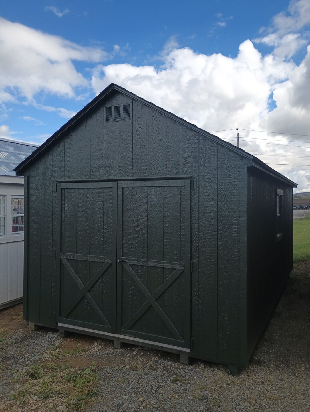 Shed with double doors, two windows and single door, shingled roof and window on other side