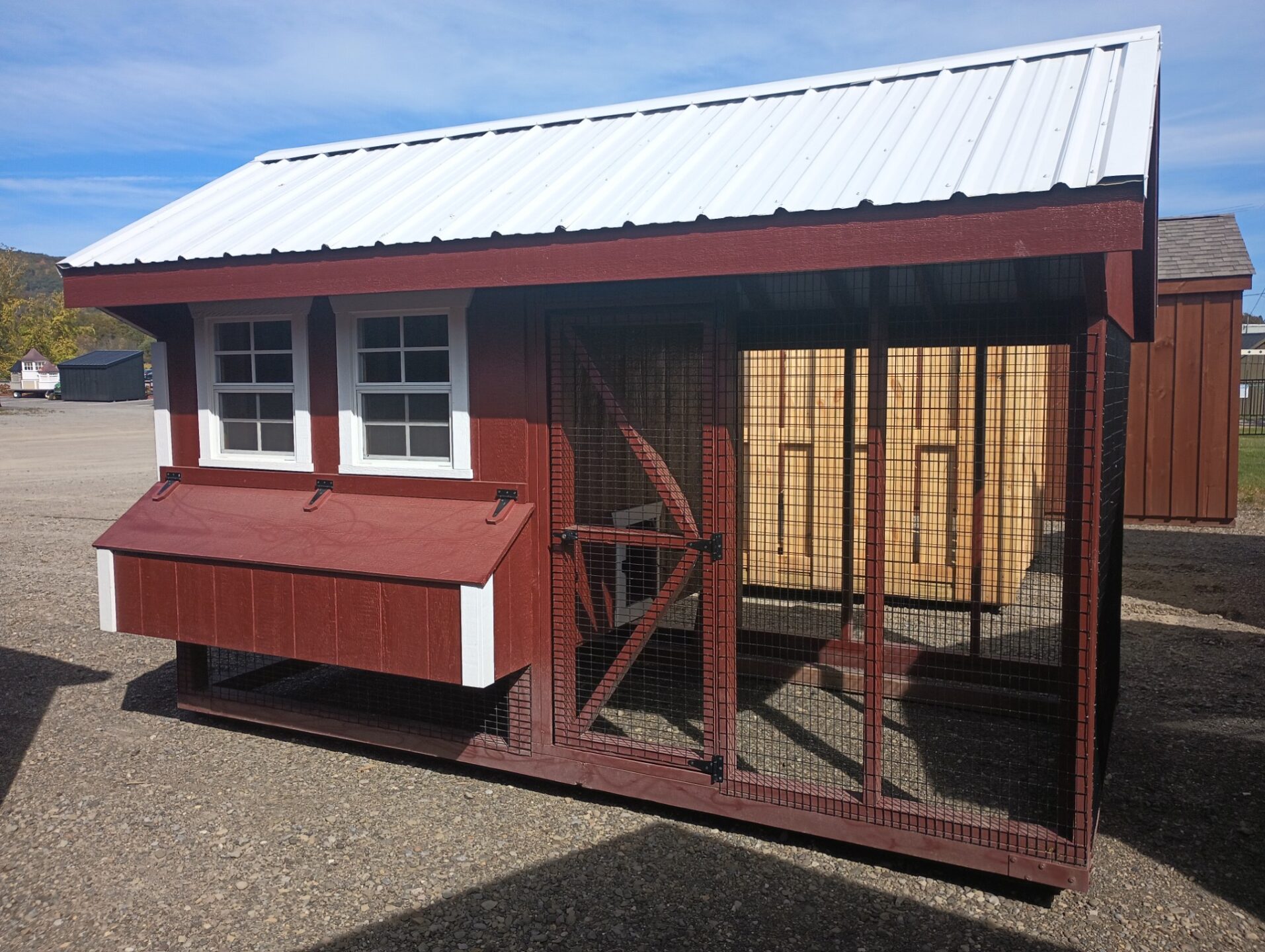 Red and white chicken coop with roost area and run area attached