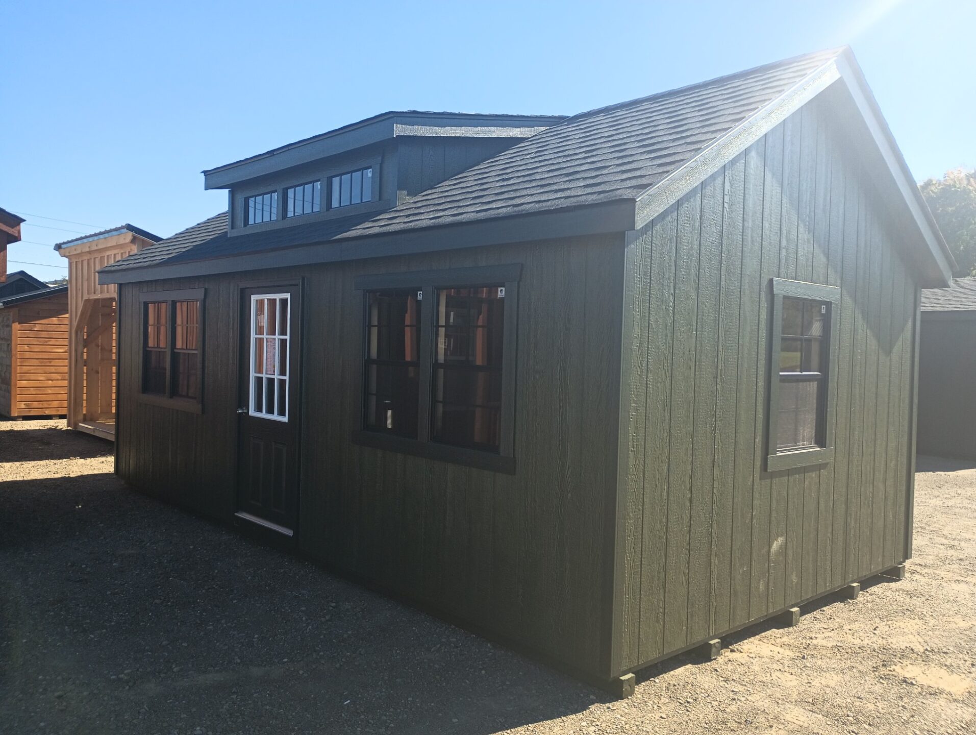 Green shed with triple transom dormer, 5 windows and single door